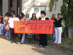 Romani women in the Czech Republic hold a protest banner that translates as "Do not sterilize our women."